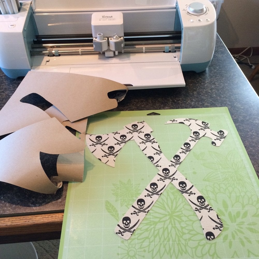 close up of cricut machine cutting out hammer and hatchet stencil