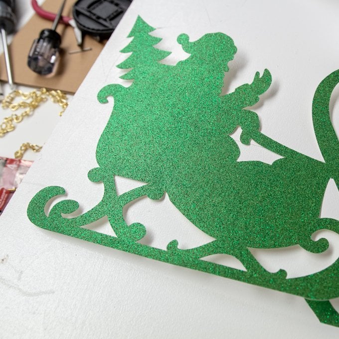 place two sheets of glitter cardstock on a 12x24 Standard Grip mat and cut the same santa sleigh image