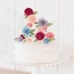 paper flower cake topper on white cake