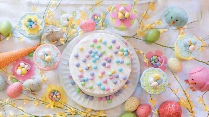 white cake, flowers, and birds on bright spring Easter table