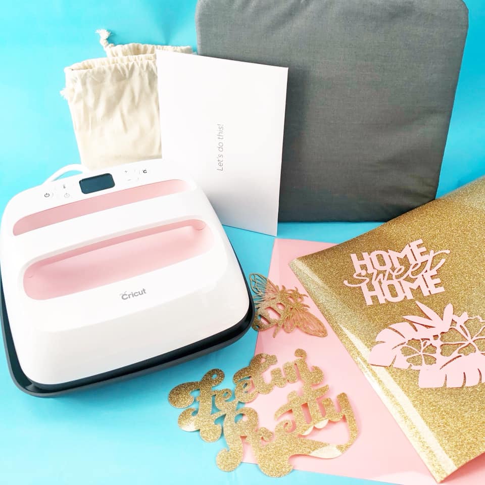 Cricut EasyPress with pink and gold craft supplies