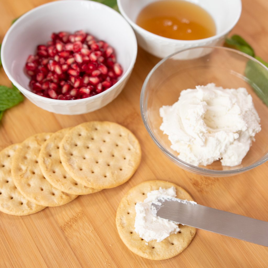spread goat cheese on crackers