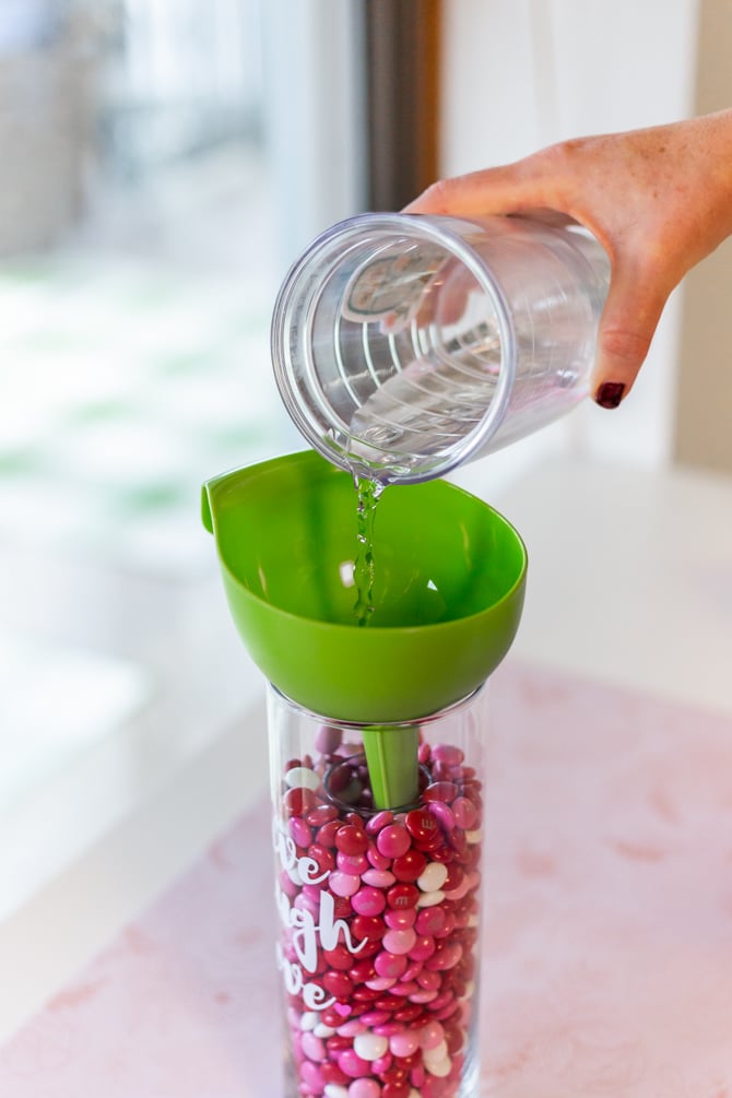 water being poured in vase for m&ms inside large vase for valentine's day candy craft