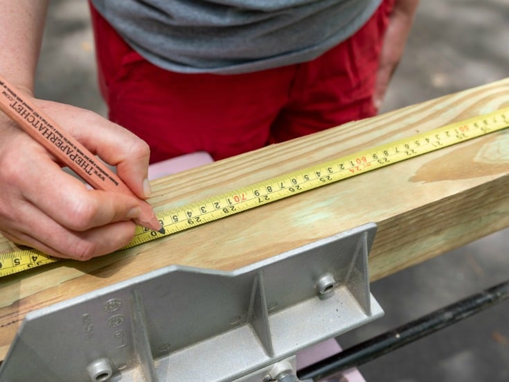 woman measuring wood lumber