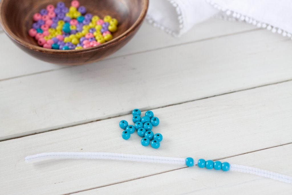 string blue beads on to pipe cleaner