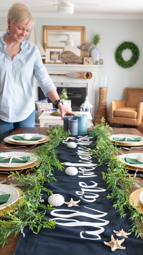 woman setting table with coastal and custom table runner with Cricut Smart Materials