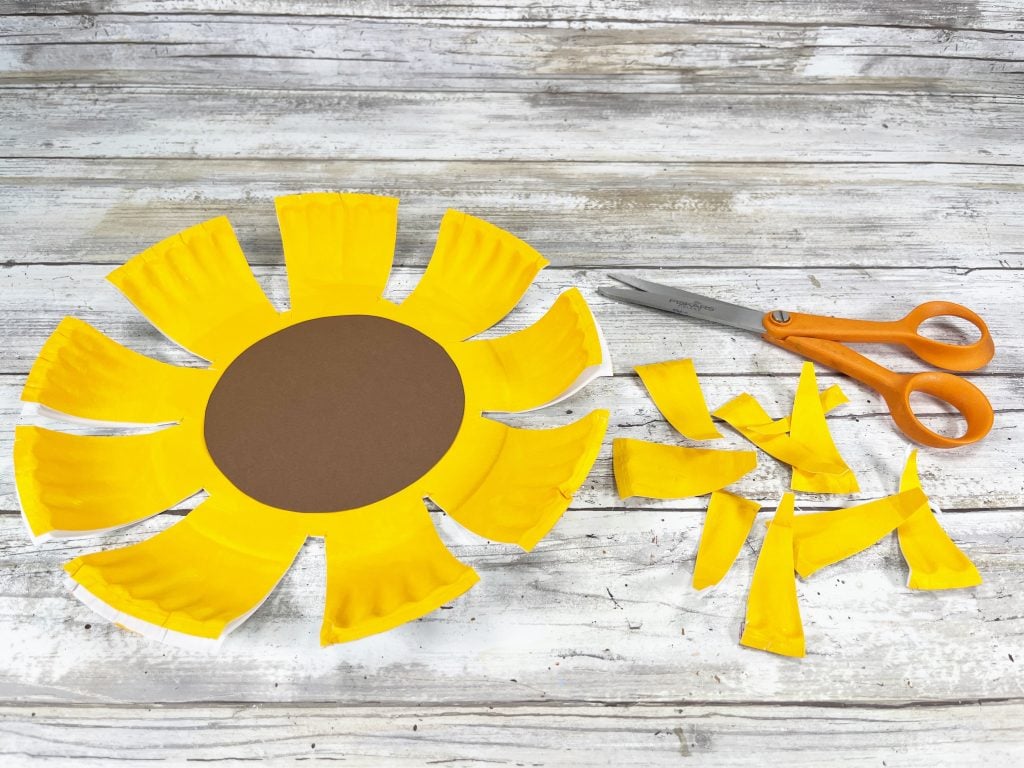 cutting petals of sunflower paper plate