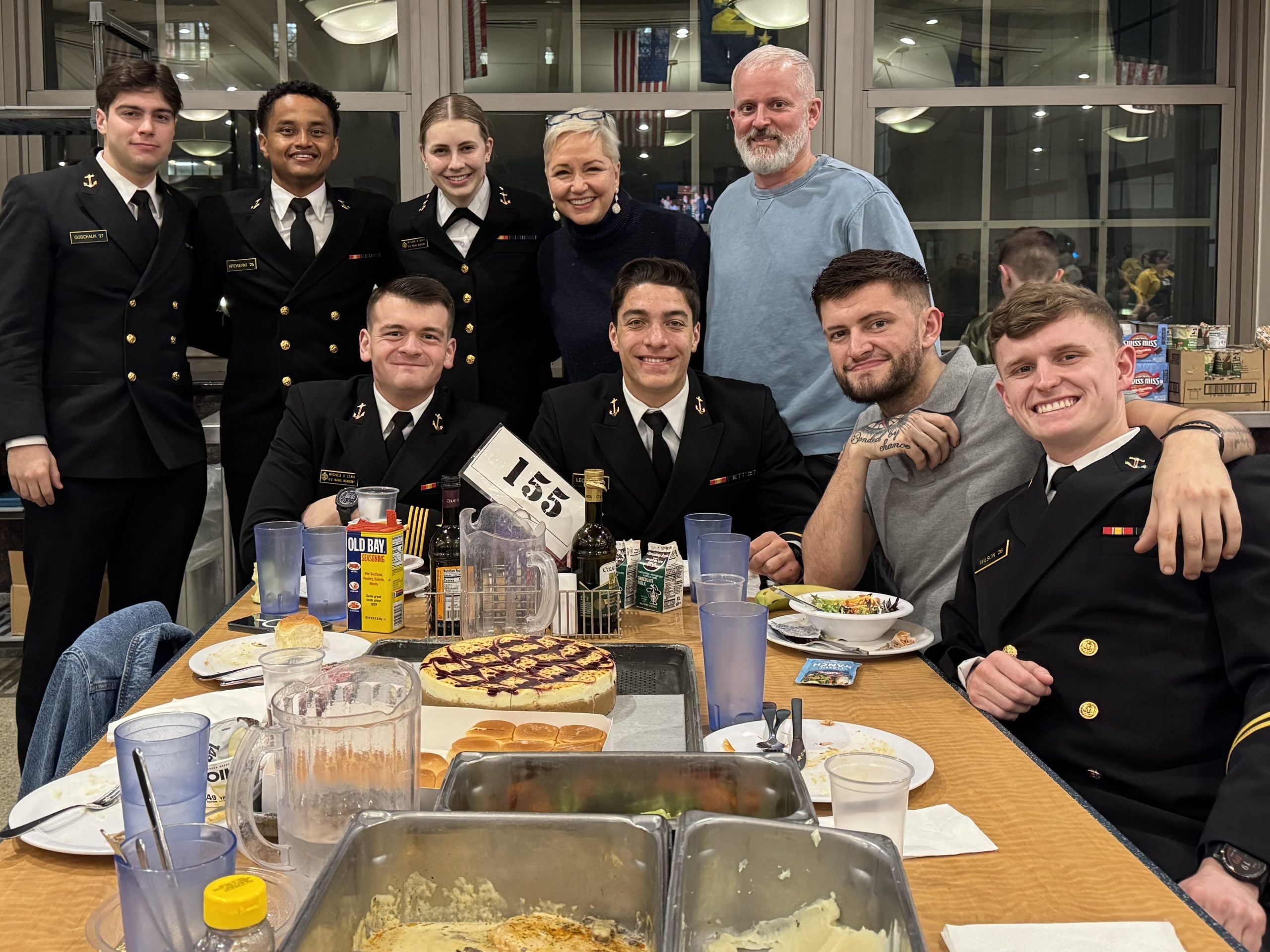 group of military men and woman around a table smiling at the camera