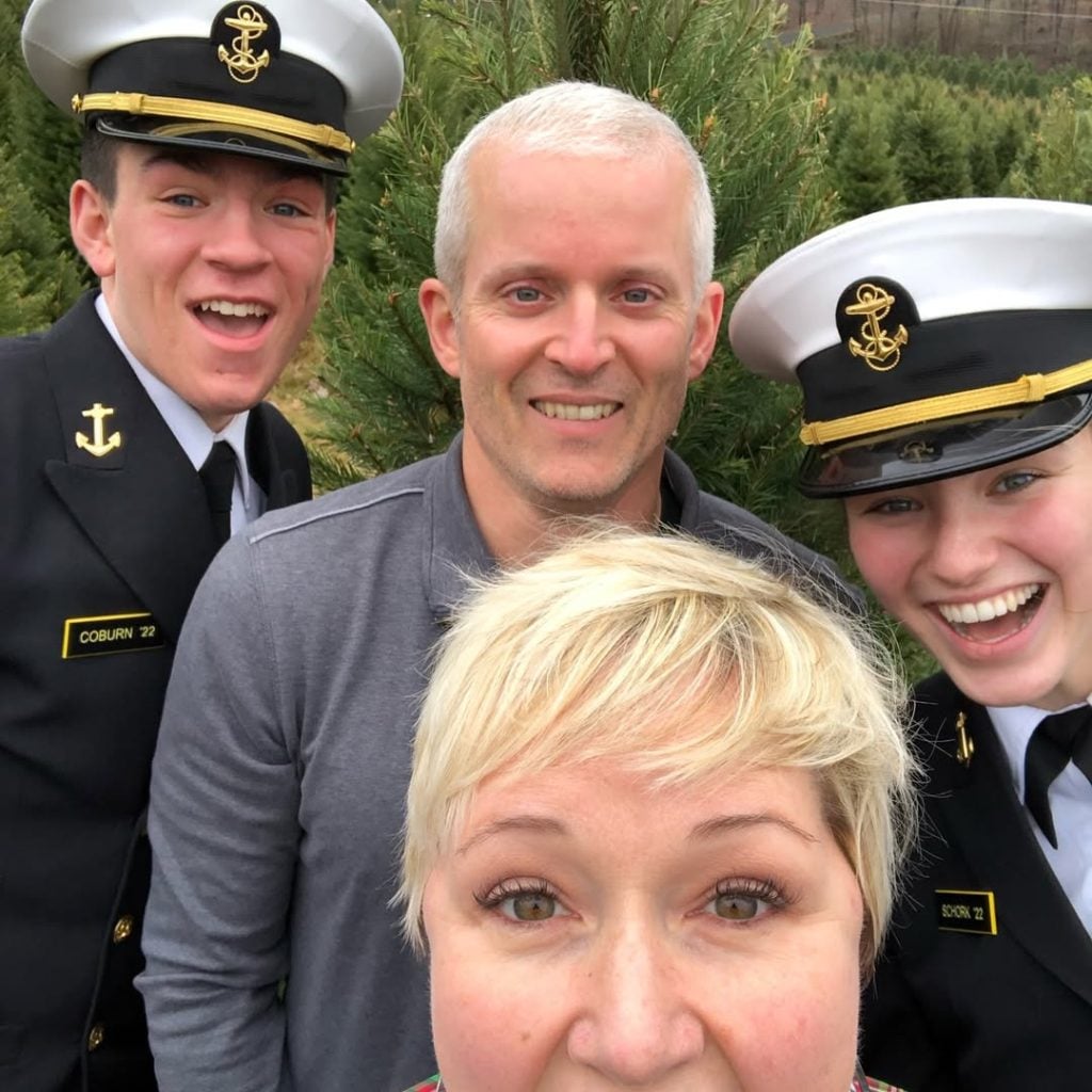 man and woman in military uniform smiling with couple outside